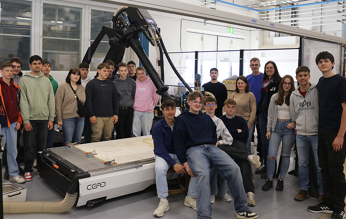 opiskelijoita tutustumassa robottisoluun