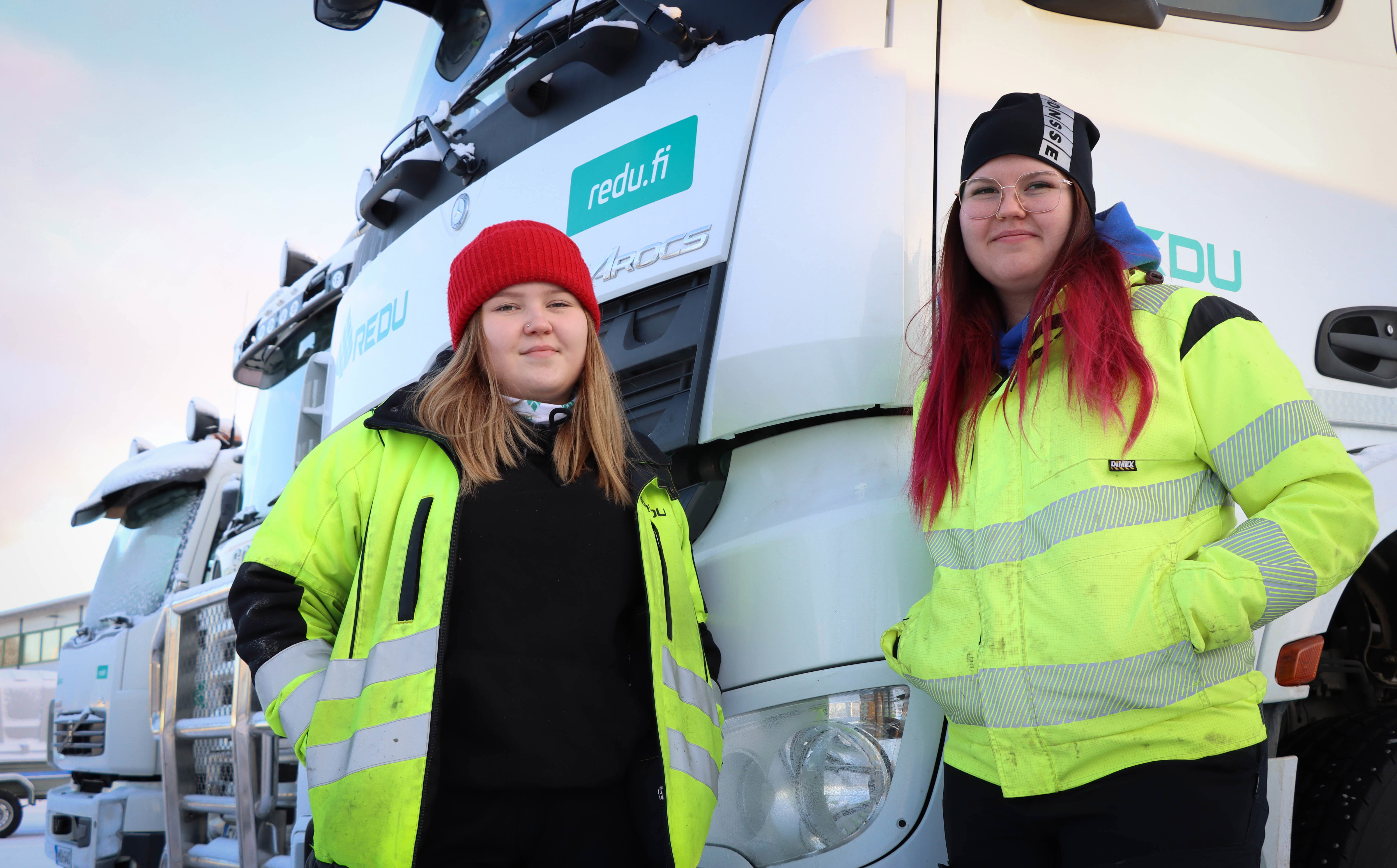 Logistiikan opiskelijat Anna ja Iina seisovat kuorma-auton edessä.