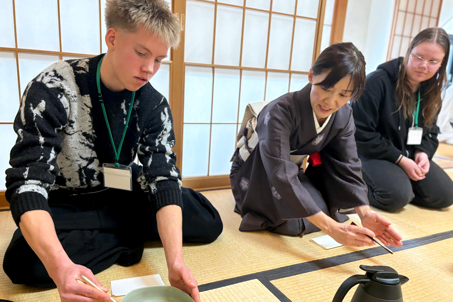 Eeli Körkkö Japanin Sapporossa istumassa lattialla opettajan ja opiskelijan vieressä.