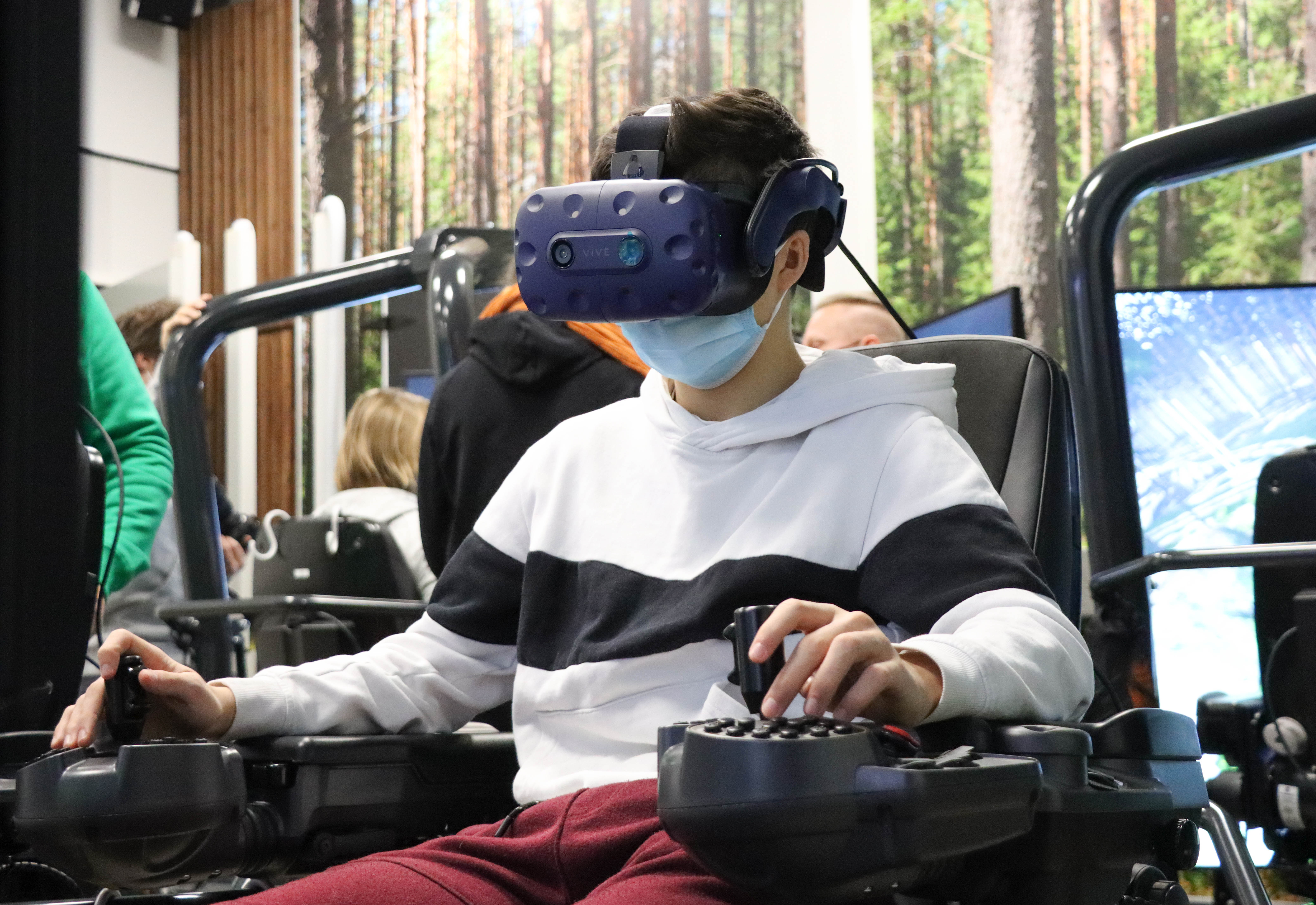 Opiskelija harjoittelee simulaattorilla VR-lasit päässään.